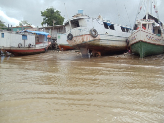 Construtor artesanal  de Abaetetuba, calafetando barco à beira do rio