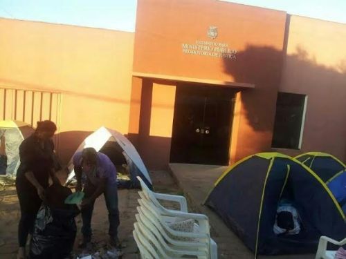 Grevista faz limpeza da calçada onde os manifestantes acampam, em frente ao Ministério Público