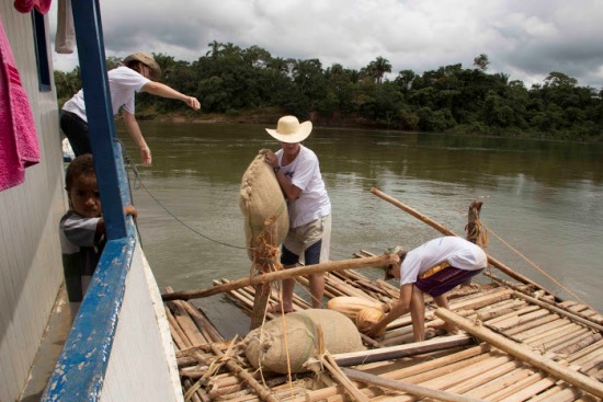 Embarcando sacos de milho e arroz, como faziam os antepassados.