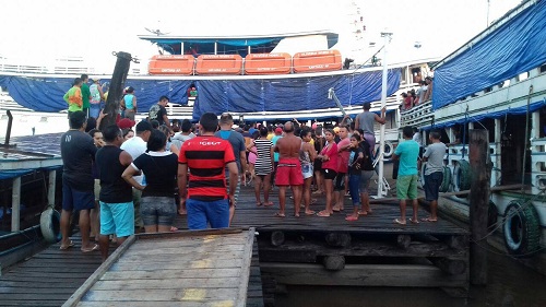 Populares cercam embarcação, ancorada no cais - depois da tragédia