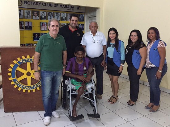 Karam, à esquerda, entrega cadeira de rodas à família de deficiente